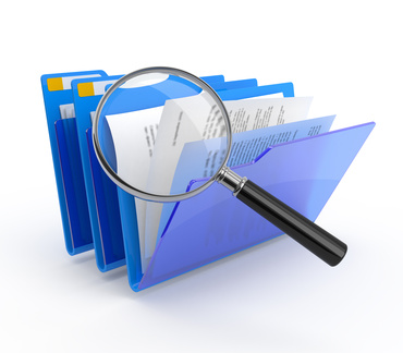 Magnifying glass over file folders [Image © Modella - Fotolia.com]